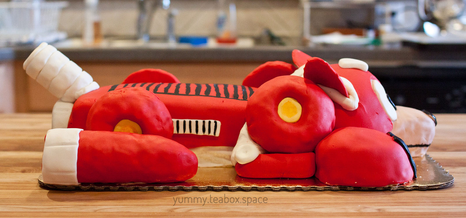 Side view of a cake that looks like the red robot dog, Rush, from Mega Man