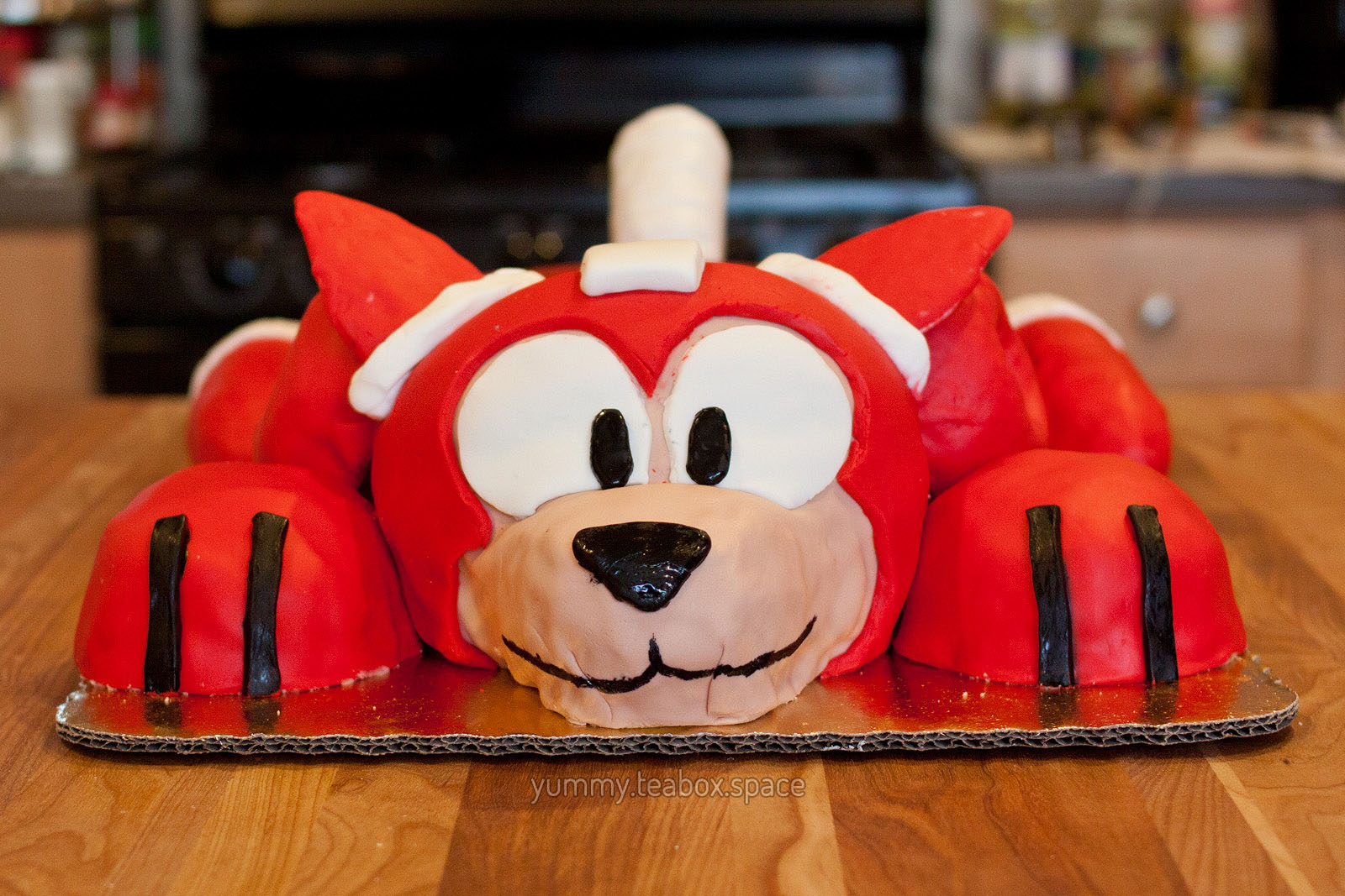Front view of a cake that looks like the red robot dog, Rush, from Mega Man