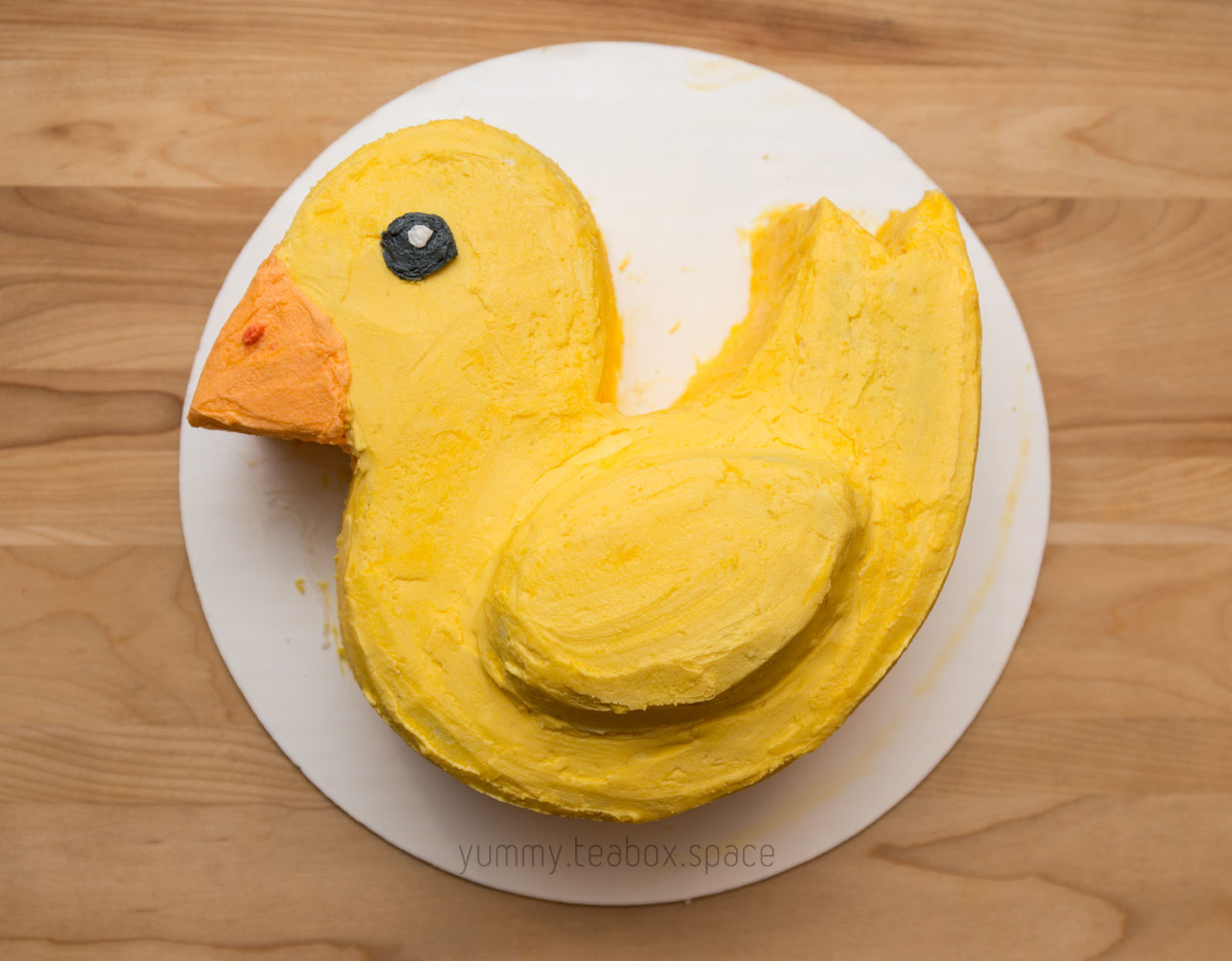 Cake that looks like a yellow duck with an orange beak